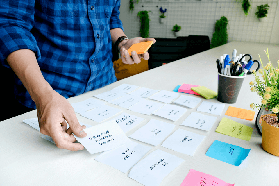 A picture of a desk with post it notes stuck on top